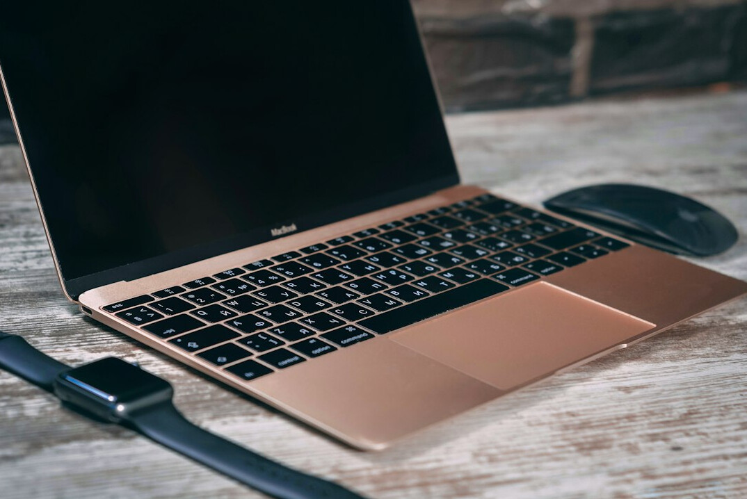 Dvoje kolega zajedno pregledava programski kod na laptopu
