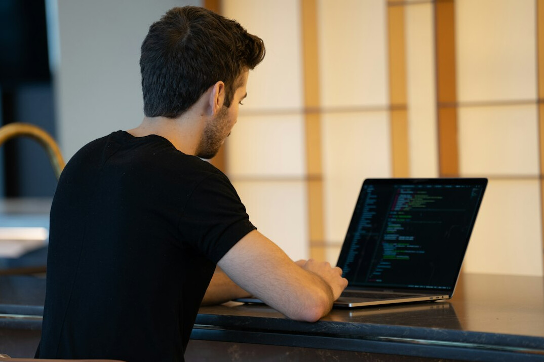 person coding on laptop